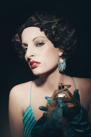 Retro 1920s woman doing perfume with vintage vaporizer.