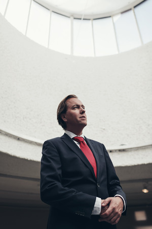 Satisfied happy young businessman standing under dome of light.の写真素材