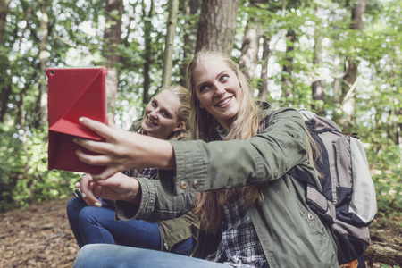 Twin sister making selfie in forest.の写真素材