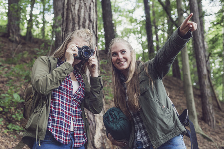 Two woman photographing in summer forest.の写真素材