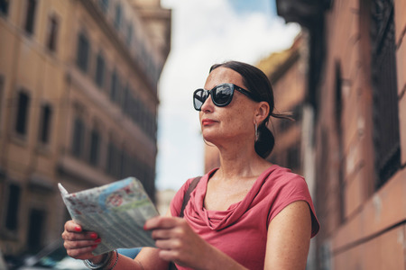 Map reading female tourist with sunglasses in Rome, Italy.の写真素材