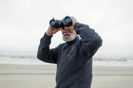 Beachcomber on the beach looking with binocular.