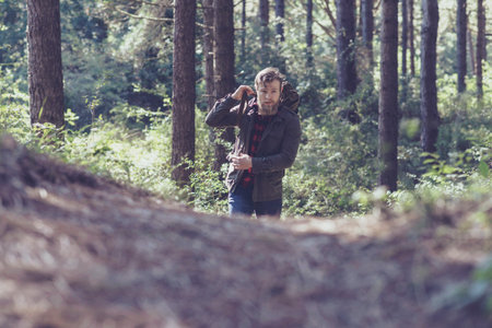 Beard man hiking on forest trail.