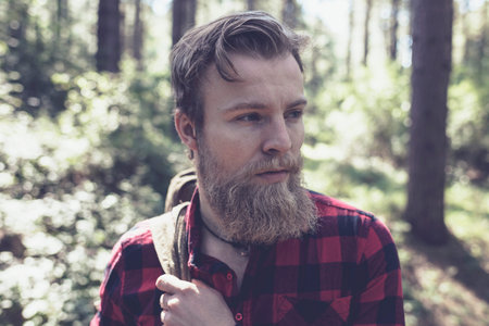 Man with beard in forest.