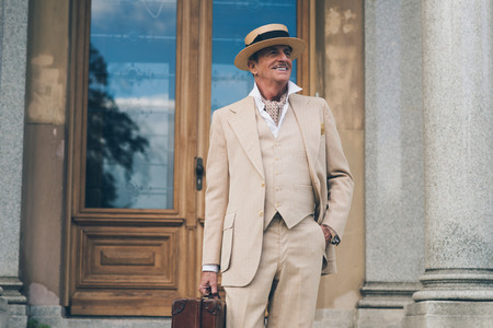 Smiling retro dandy standing at front door of his mansion.の写真素材
