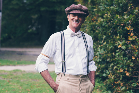Smiling senior vintage fashion man enjoying his garden.の写真素材