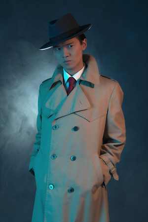 Mysterious retro 1940 asian gangster fashion man in raincoat.の写真素材