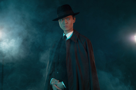 Scary retro 1940 asian gangster fashion man. Wearing long coat.の写真素材