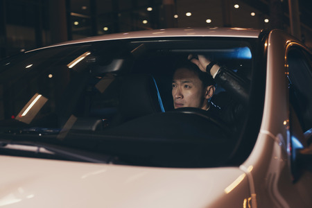 Asian man in car doing his hair.の写真素材