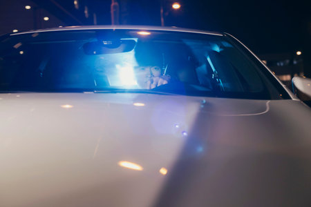 Asian man in car at night.