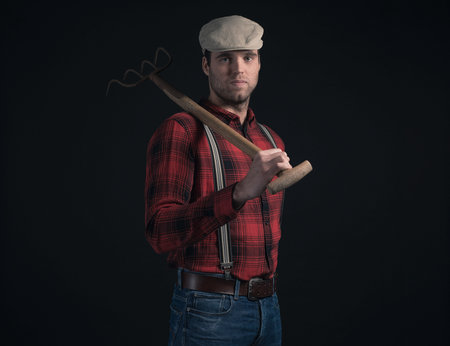 Cool fashionable farmer wearing red checkered shirt and cap.