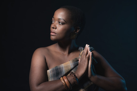 Profile shot of traditional xhosa woman wearing brown fabric and bracelets.の写真素材
