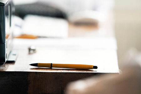 Yellow ballpoint on wooden desk.の写真素材
