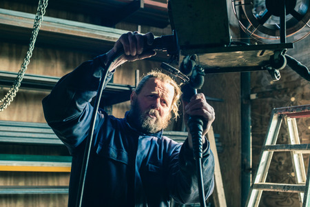 Man with beard preparing welding machineの写真素材