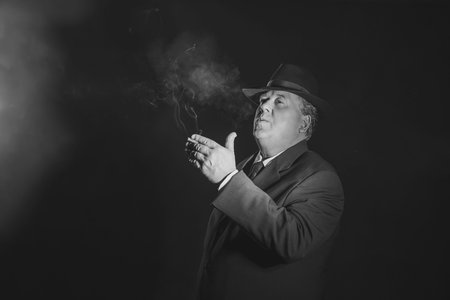 Retro 1930s gangster smoking cigar. Classic black and white portrait.