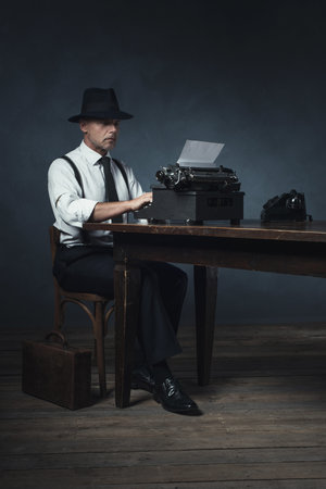 Vintage 1940 office worker behind desk with typewriter and telephone.の写真素材