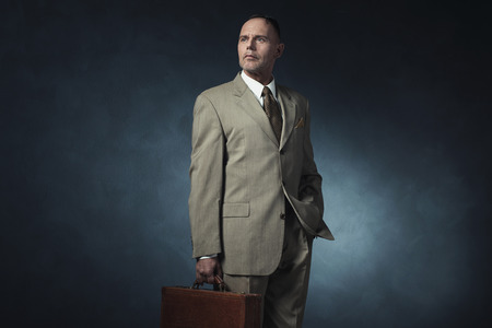 Vintage 1940 office worker standing with briefcase.の写真素材