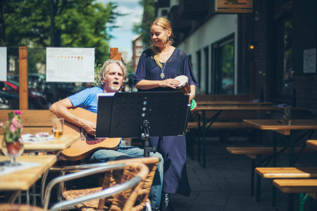 Street musicians performing acoustic in summertime at outdoor cafe. Amsterdam. The Netherlands.の写真素材
