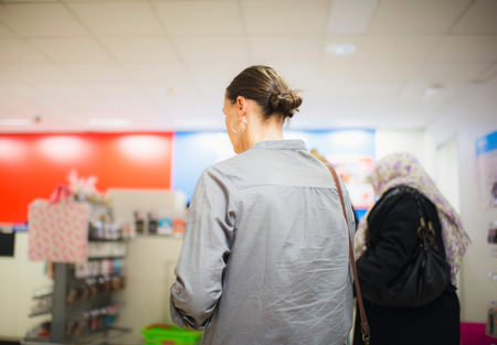 Rear view of brunette woman standing in line at the checkoutの写真素材