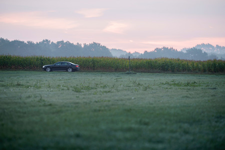 Car driving through rural misty landscape.の写真素材