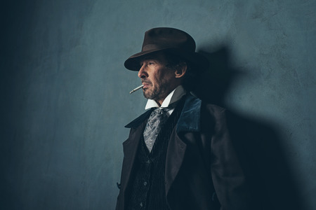 Retro 1900 western man with beard smoking cigarette.の写真素材