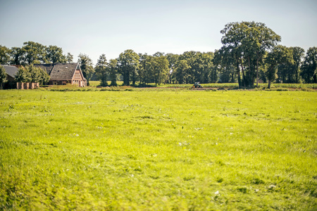 Dutch rural landscape with farm and tractor in summer. Winterswijk. Achterhoek. Gelderland. The Netherlands.の写真素材