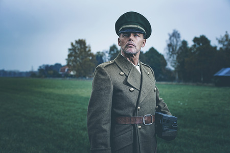 Retro 1940s military officer standing in field with phone.の写真素材