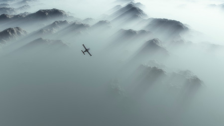 Aerial of single engine airplane over mountain range in thick layer of mist.の写真素材