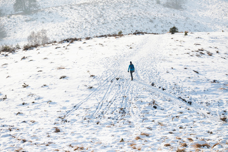 Hills covered in snow with hiker.の写真素材
