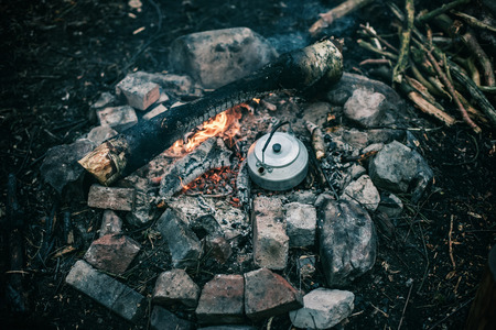 Metal kettle boiling water on a campfire.の写真素材