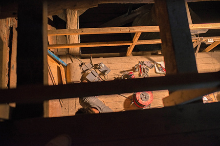 Top view of tools and electricity parts lying on wooden floor in attic of church. Restoration work.の写真素材