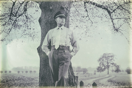 Antique black and white photo of 1940s military officer smoking cigarette under tree.の写真素材