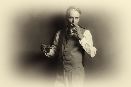 Antique plate photo of vintage businessman 1920s style smoking cigar and holding glass of whiskey.の写真素材