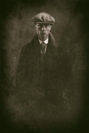 Antique wet plate photo of threatening 1920s english gangster in smoky room.