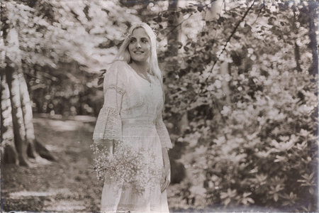 Vintage black and white photo of smiling bride in white dress in forestの写真素材