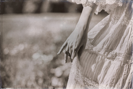 Vintage black and white photo of hand of bride holding dressの写真素材
