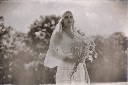 Vintage black and white photo of bride with white flowers in nature