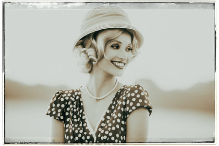 Classic black and white photo of smiling woman wearing retro 1920s clothing. Standing in rural...