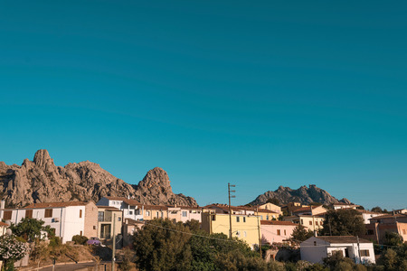 Colorful houses in evening sunlight against mountain landscape. Sardinia. Italy.の写真素材