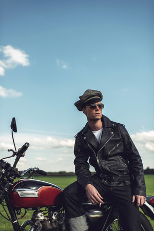 Vintage motorcyclist having a break along rural road in summer.の写真素材