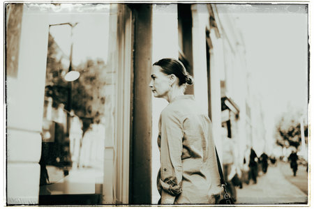 Vintage black and white photo of woman on street looking into storefrontの写真素材
