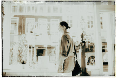 Vintage black and white photo of woman standing inside shop at storefrontの写真素材