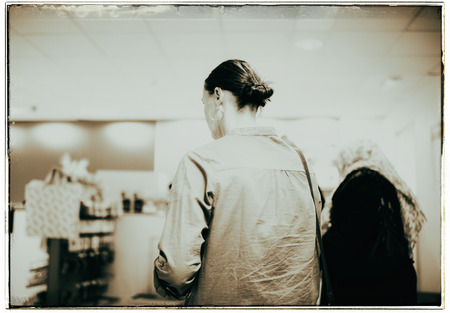 Vintage black and white photo of woman standing in line at the checkoutの写真素材