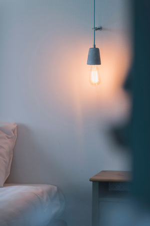 Vintage lightbulb hanging on wall in bedroom.の写真素材