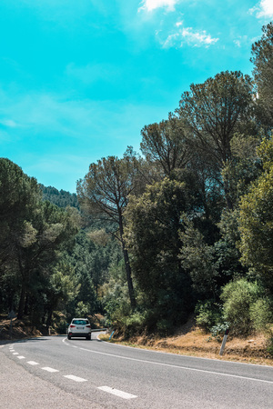 White car driving on mountain road. Rear view. Sardinia. Italy.の写真素材