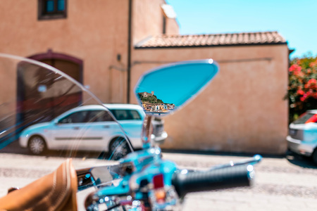 Colorful houses of Bosa seen in rear view mirror of parked motorcycle. Sardinia. Italy.の写真素材