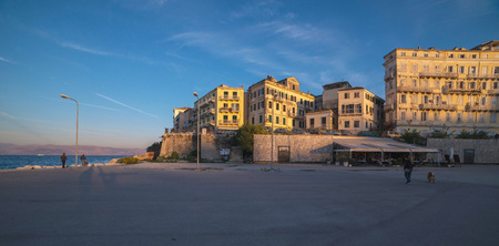 Architecture in low sunlight at shore under blue sky. Kerkyra, Corfu, Greece.の写真素材