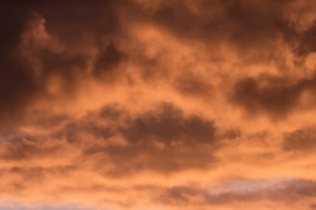 Close-up of brown orange coloured clouds during sunset.