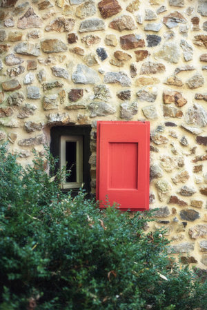 Small window with wooden shutter in countryside.