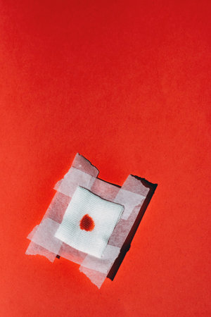 Bandage gauze with blood on red background. Top view.の写真素材